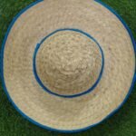 Handcrafted natural palm leaf sun hat with traditional woven design and blue border.